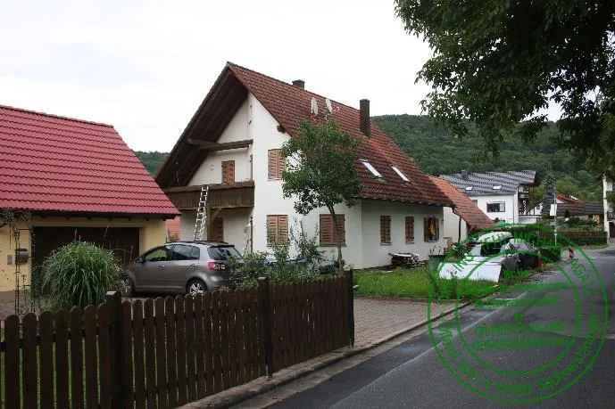 Frontale Hauptfassade des Gebäudes mit Garage und Straßenseite