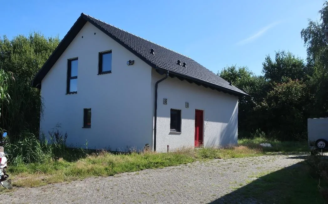 Außenansicht Wohnhaus mit rotem Eingang, Giebelseite