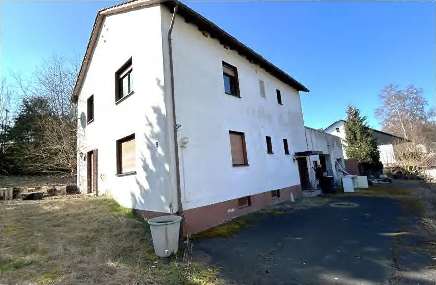 Wohnhaus mit weißer Fassade, Außenansicht schräg von der Seite bei Tageslicht