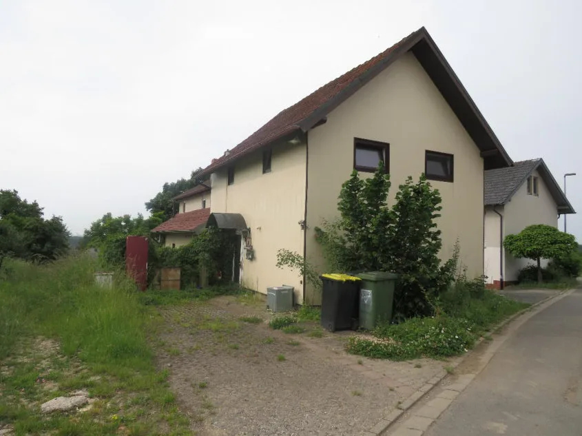 Außenansicht eines zweigeschossigen Wohnhauses mit Satteldach, Schrägansicht von der Straßenseite