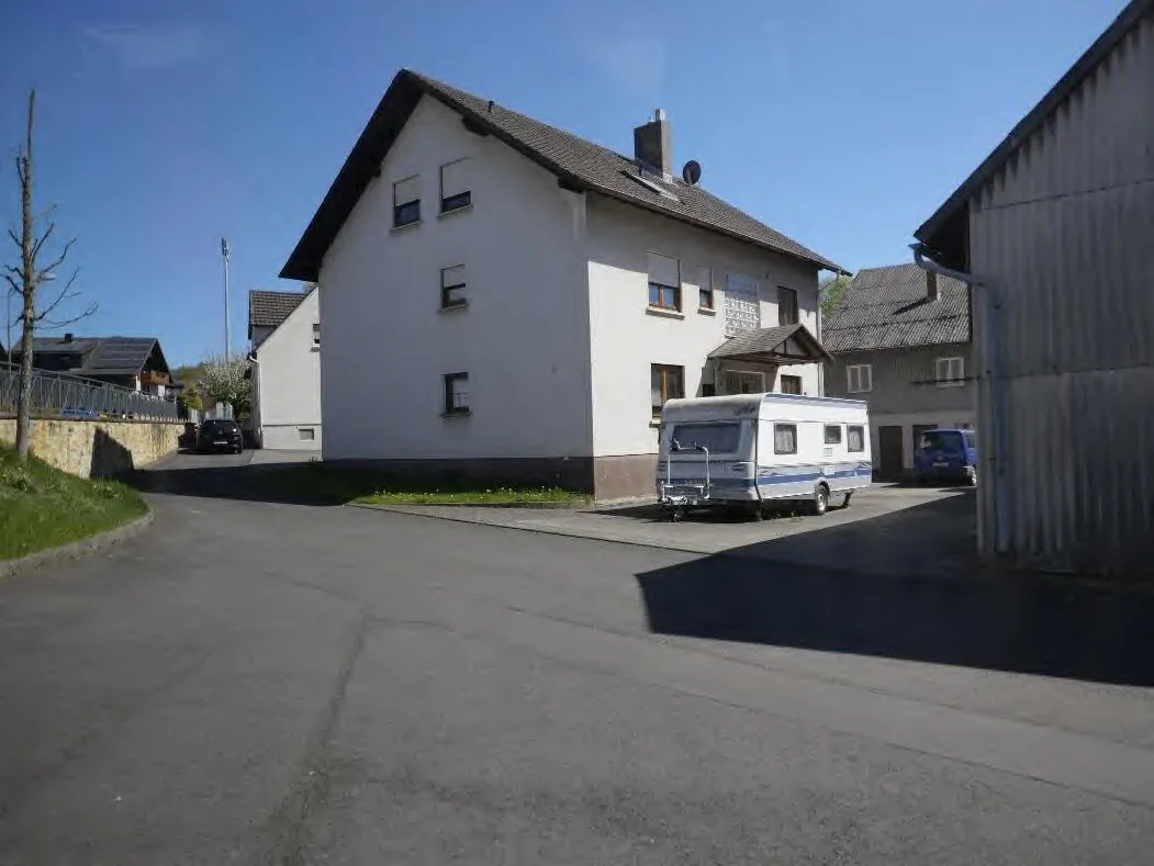 Straßenansicht des Wohnhauses mit Campingwagen und Nebengebäude