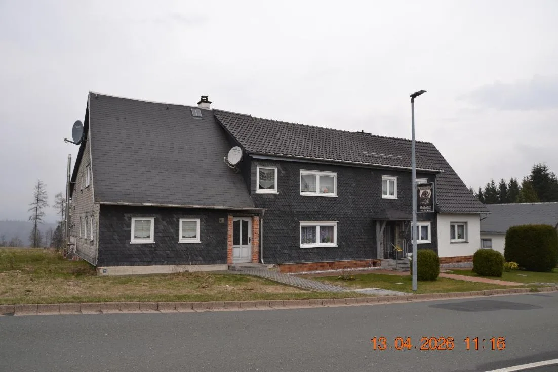 Straßenansicht des Wohnhauses mit Satteldach, Schieferfassade und Hauseingang