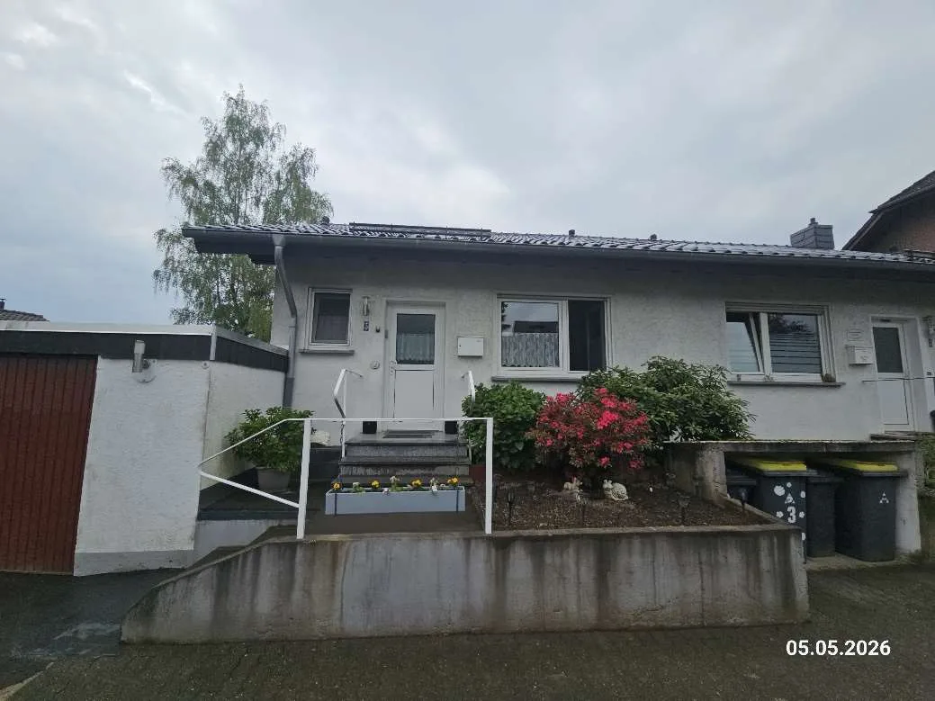 Straßenansicht des Doppelhaushälfte-Bungalows mit Eingangstreppe und Vorgarten