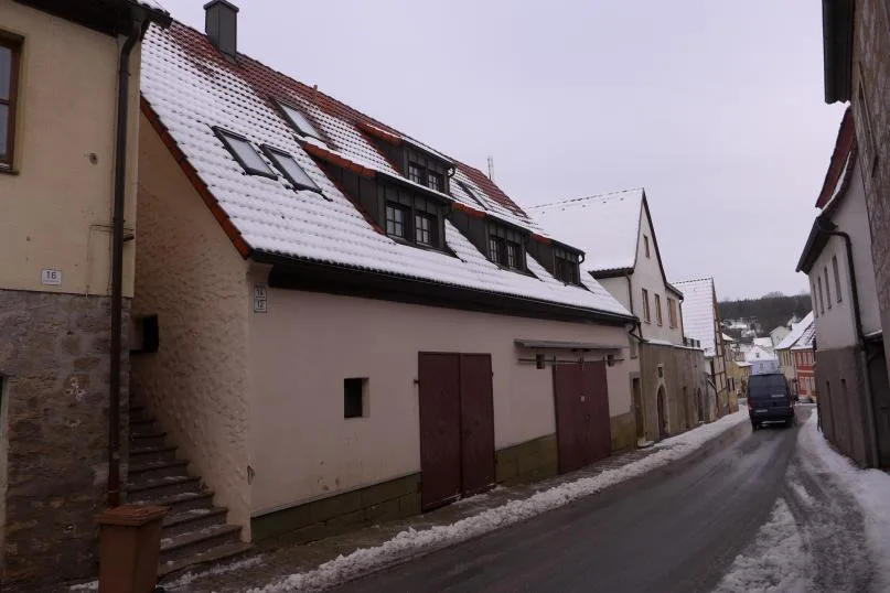 Straßenansicht: Wohnhaus mit Garagentoren und Dachgauben, Winter