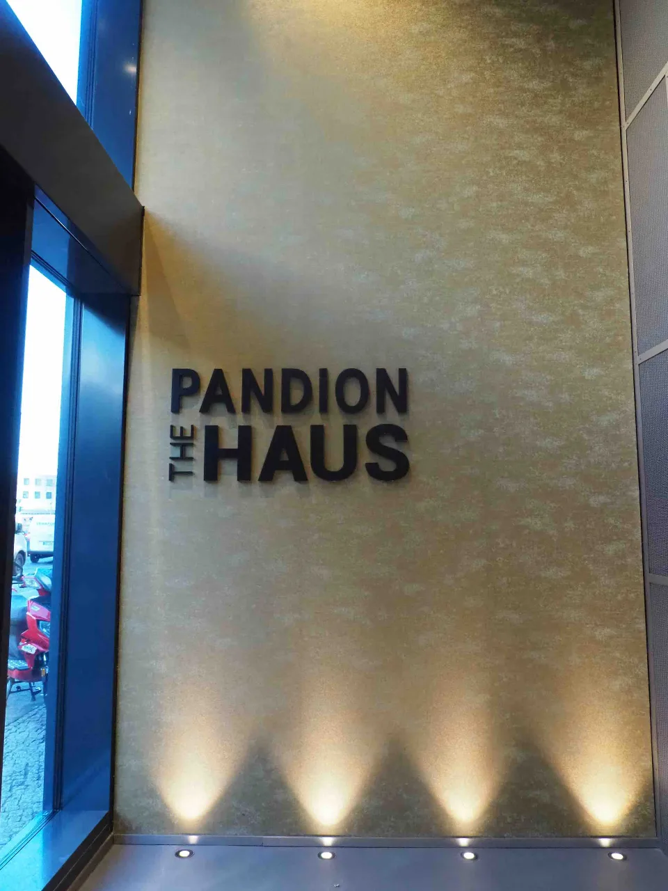 Moderne Gebäudefassade mit prominentem Schriftzug 'PANDION THE HAUS'