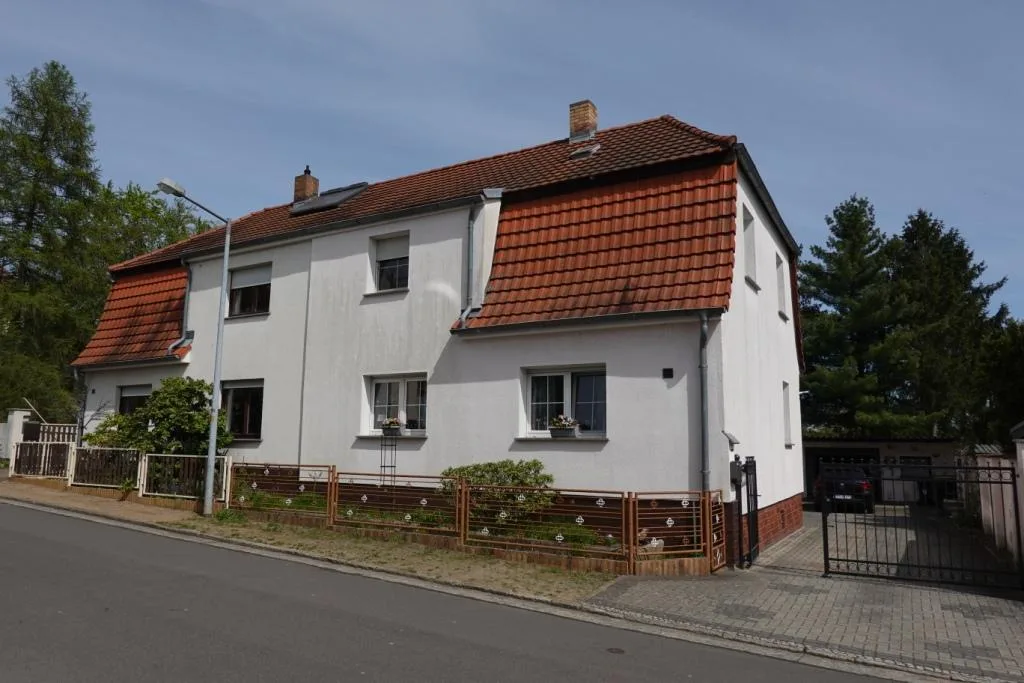 Vorderansicht des Einfamilienhauses mit roten Dachziegeln und weißer Fassade