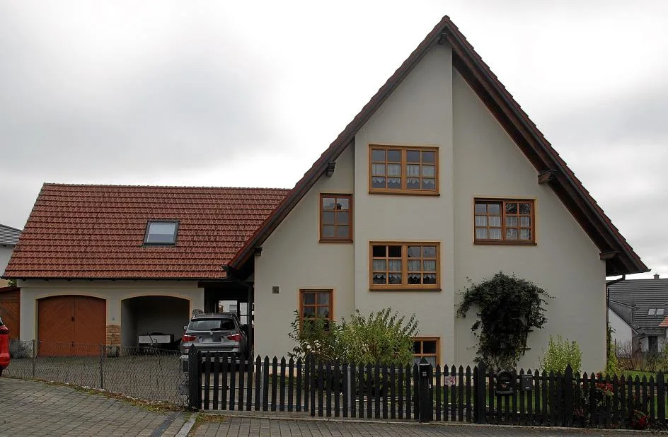 Frontansicht des Einfamilienhauses mit Garage und Einfriedung