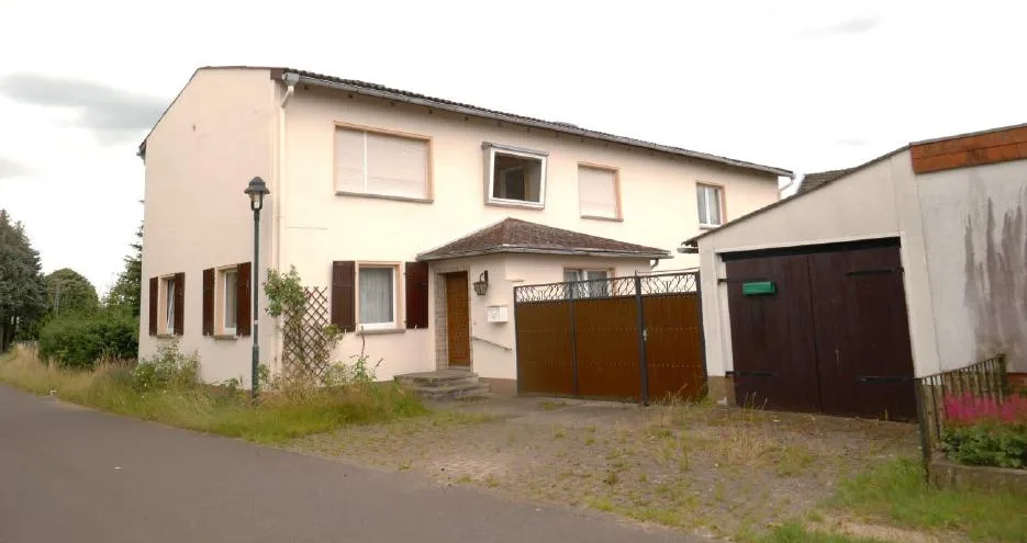 Straßenansicht des Wohnhauses mit Garage und Hofeinfahrt
