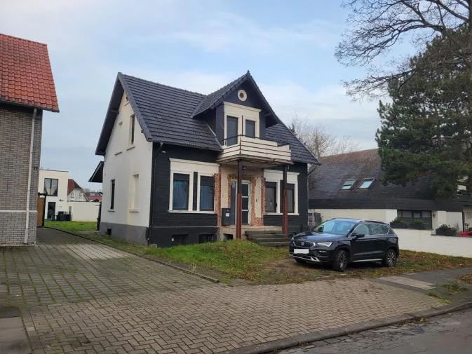 Straßenansicht der Hauptfassade mit Eingangsvorbau und Balkon