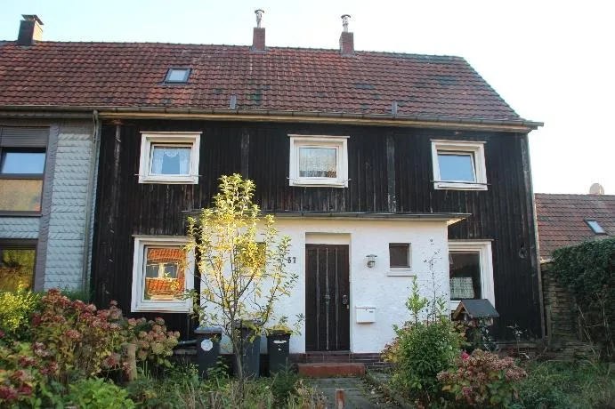Klare Frontansicht des Gebäudes mit Garten im Vordergrund – repräsentativ