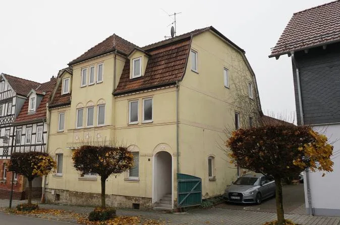 Frontansicht des Gebäudes mit Eingang und parkendem Pkw
