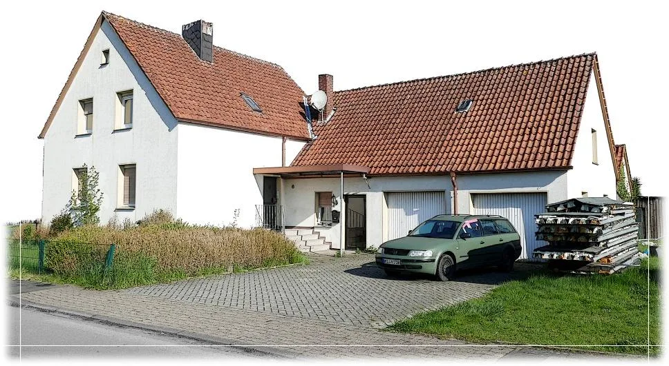 Außenansicht des Wohnhauses mit Garage und Pkw auf der Pflasterzufahrt
