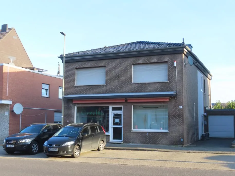 Straßenseitige Frontansicht des zweigeschossigen Gewerbe-Wohnhauses mit Hausnummer 31 und Ladeneingang