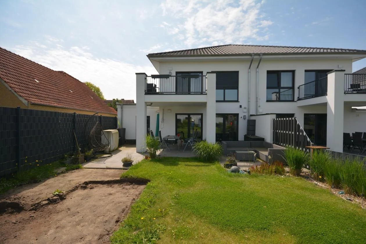 Rückansicht des Doppelhauses mit Terrasse und gepflegtem Garten