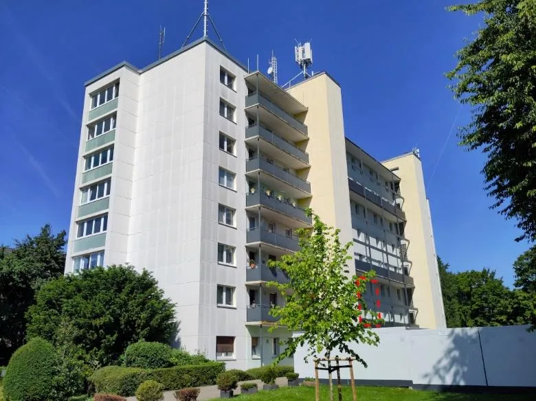 Außenansicht eines mehrgeschossigen Wohnhochhauses mit Balkonen bei klarem Himmel