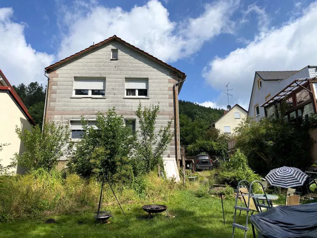 Rückansicht des Wohnhauses mit Satteldach und Garten im Vordergrund