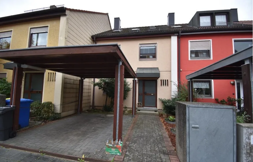 Frontansicht des Reihenmittelhauses mit Eingangstür und Carport